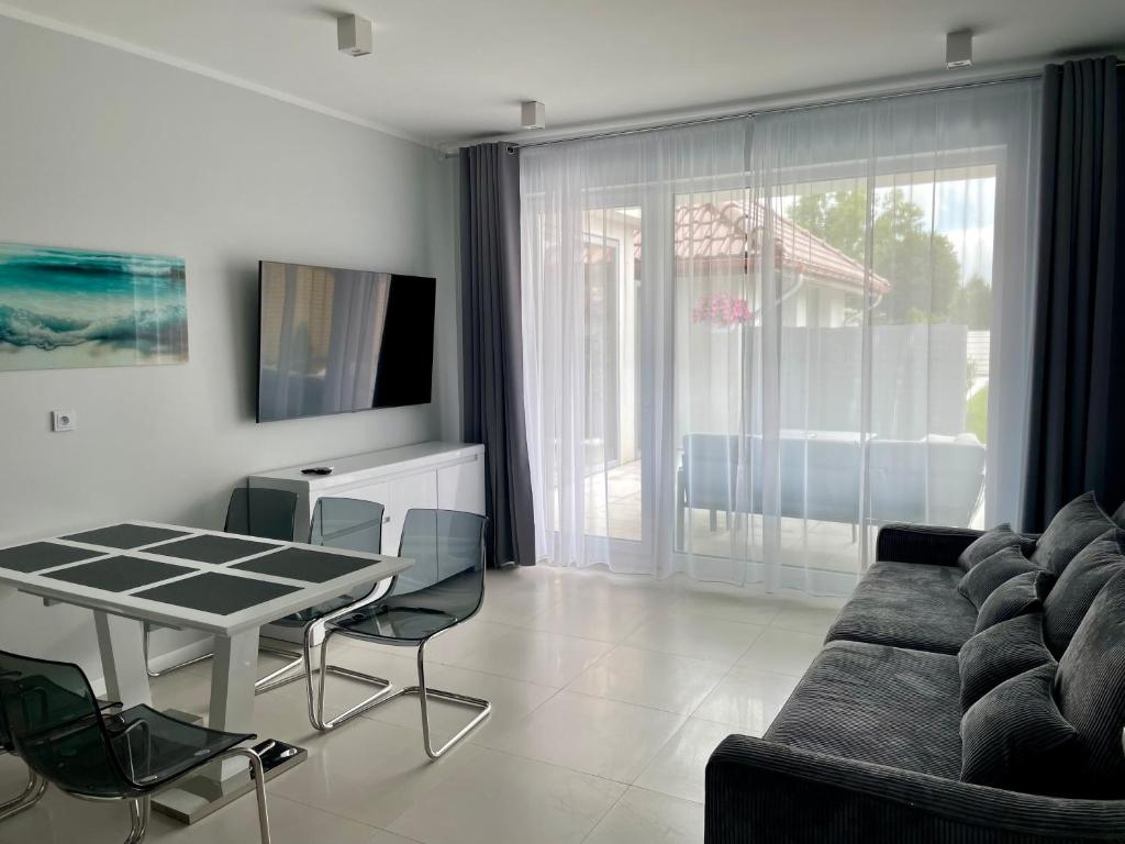 Televízia a/alebo spoločenská miestnosť v ubytovaní Apartamenty AQUA MAZURY