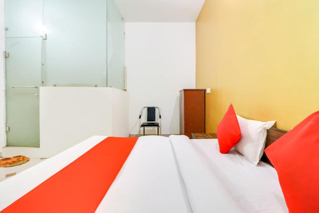 a bedroom with a large white bed with red pillows at Super OYO Hotel Olive in Rohtak