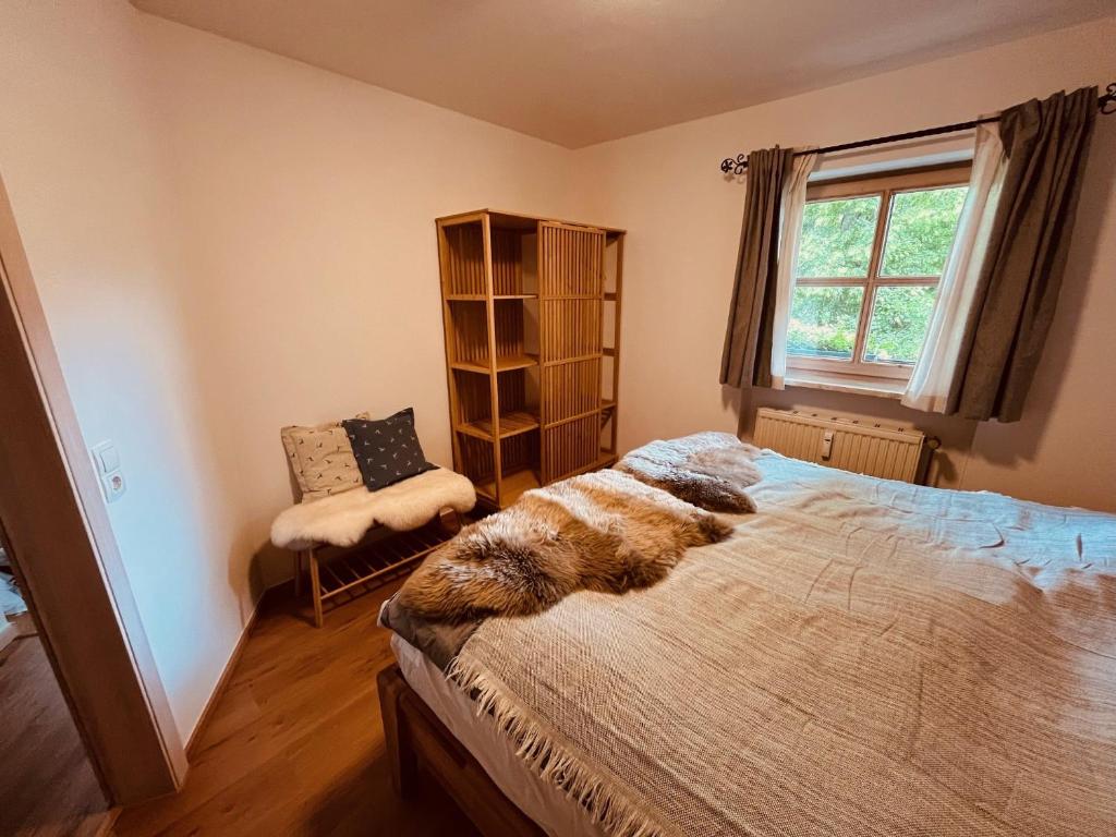 a bedroom with a large bed and a window at Achentalglück in Unterwössen