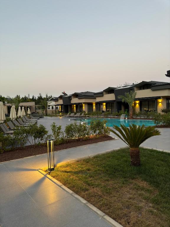 a resort with a pool and a parking lot at Minta Hills Villas Kemer in Antalya