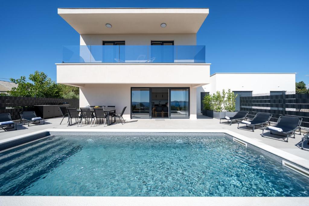 a villa with a swimming pool in front of a house at Villa La Vista e Bella in Kožino