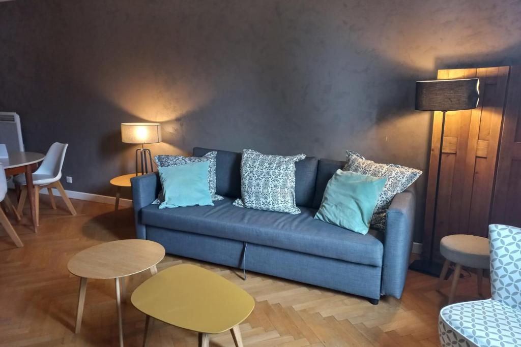 un salon avec un canapé bleu et des tables dans l'établissement Charmant T2 refait à neuf Annecy centre et lac, à Annecy