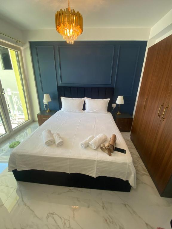 een slaapkamer met een groot bed met een kroonluchter bij Apartments Mosha in Ohrid