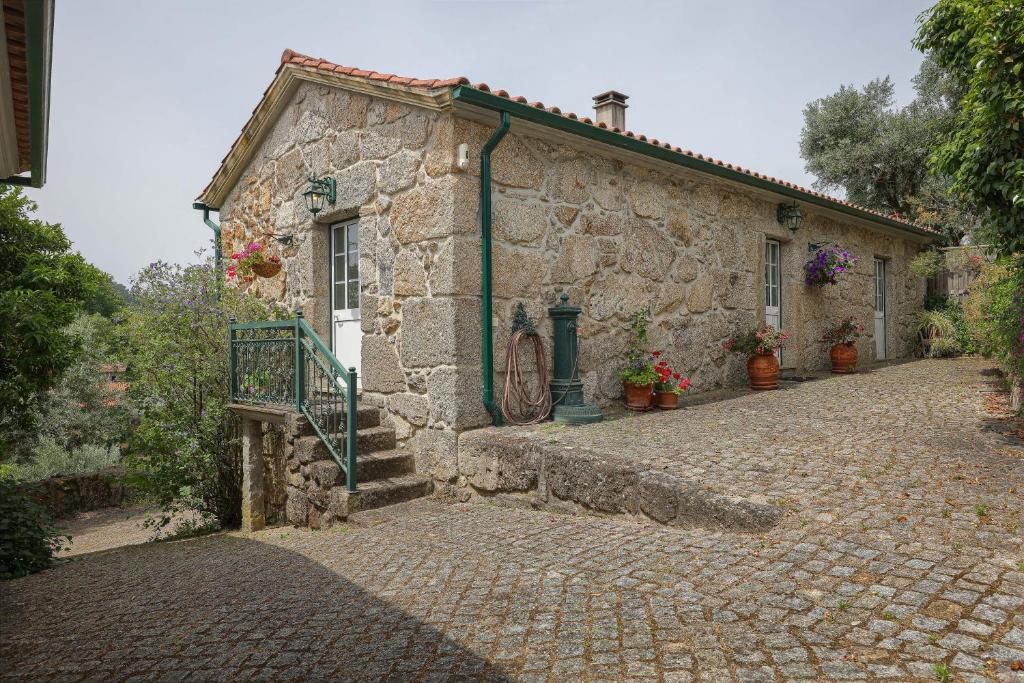 a stone building with a gate on a cobblestone street at Cosy apartment at Portuguese Quinta in Casal Diz