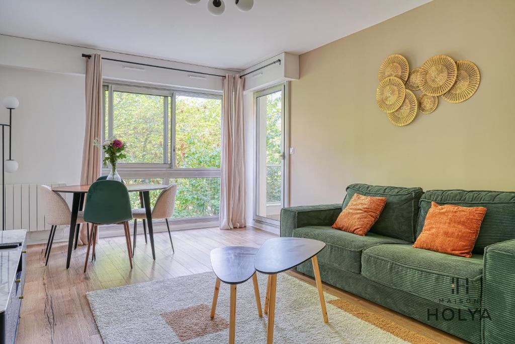 un salon avec un canapé vert et une table dans l'établissement Le Bora - Proche de Paris - 339B, à Nogent-sur-Marne