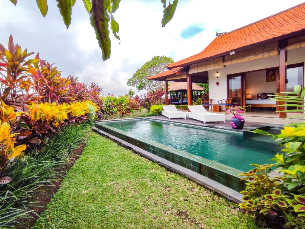 a swimming pool in the backyard of a villa at Villa Maya Ubud, Peaceful Rice Field View in Ubud