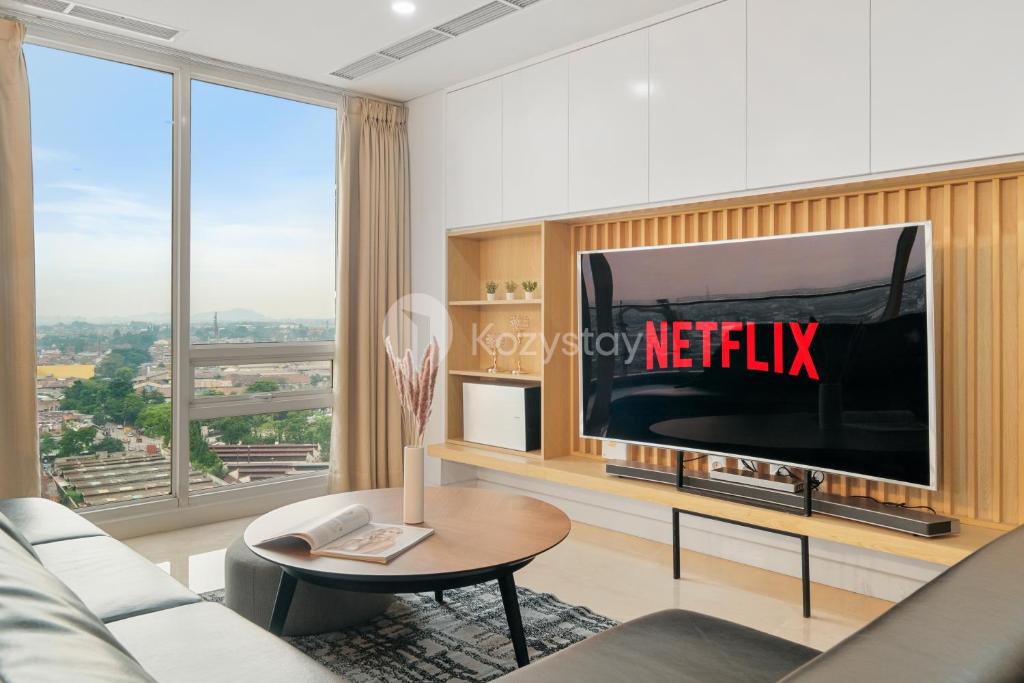 a living room with a large television and a table at Karaton by Kozystay - Paskal in Bandung