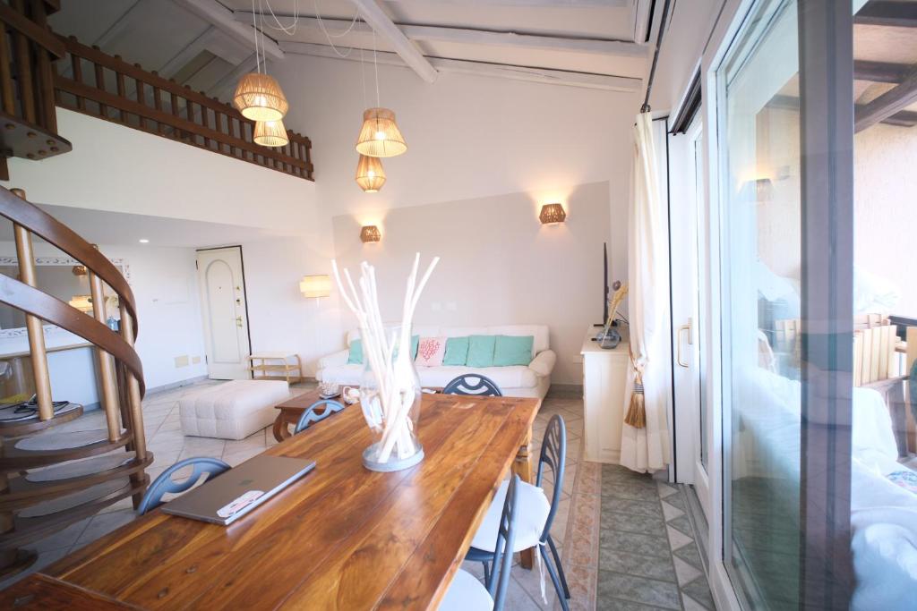 a room with a wooden table and a living room at Porto Rotondo home with Pool access & Sea Views in Porto Rotondo