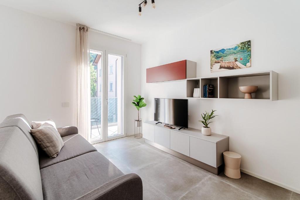 Una sala de estar blanca con un sofá y una mesa. en Lario Suite Apartments by Quokka 360 - Close to Como Downtown, en Como
