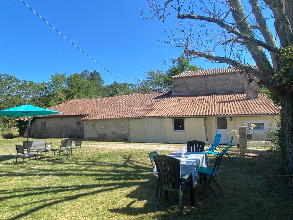 une table et des chaises devant une maison dans l'établissement Maison de campagne en pierres 4 personnes, à Gardonne