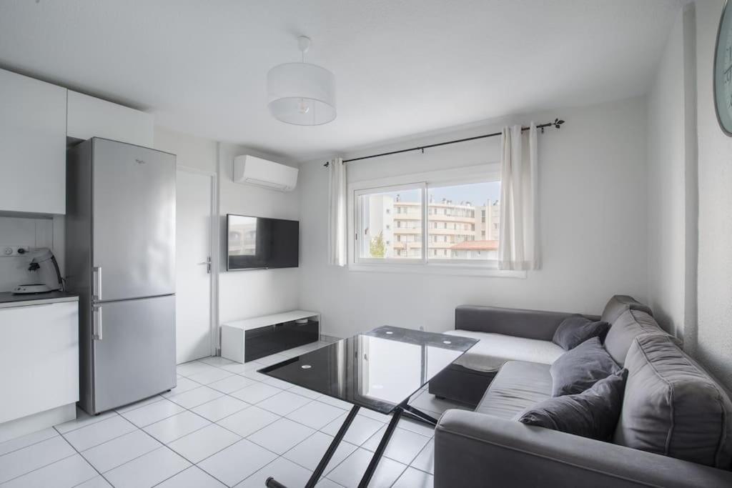 - un salon avec un canapé et un réfrigérateur dans l'établissement T2 proche mer et commerces, à Palavas-les-Flots