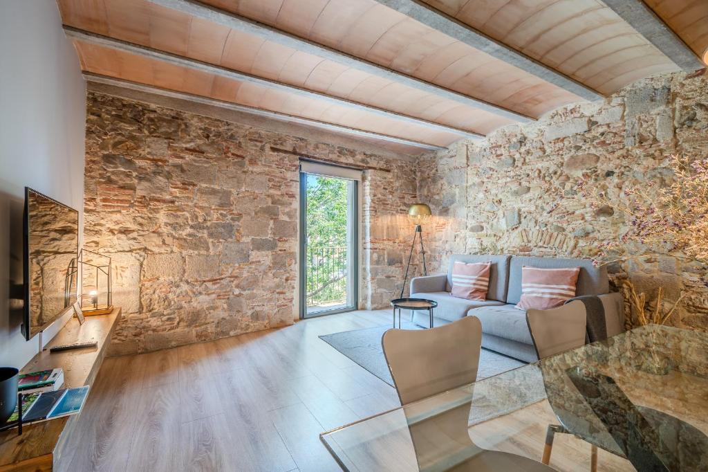 a living room with a stone wall at Flateli -Plaça Catalunya 3-2 in Girona
