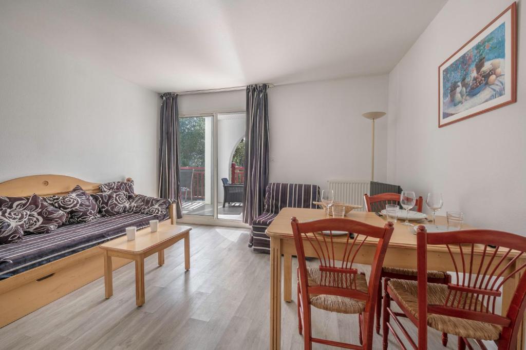 un salon avec un canapé et une table dans l'établissement Appartement pour 4 avec Piscine et Jacuzzi, au Pouliguen
