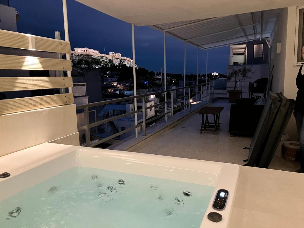 a bath tub sitting on top of a balcony at Syntagma Spa with Acropolis View in Athens