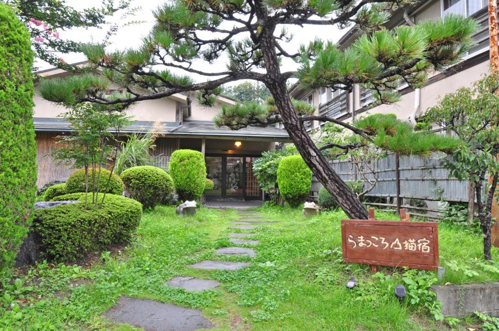 um jardim com uma árvore em frente a um edifício em Kajiyabekkan Ramakkoro Yamaneko Yado em Ichinoseki