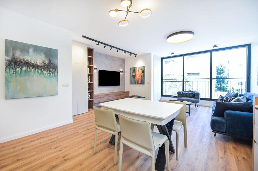 Una sala de estar con una mesa y sillas y un sofá. en Elegance 3 BR in Gordon Beach by HolyGuest, en Tel Aviv