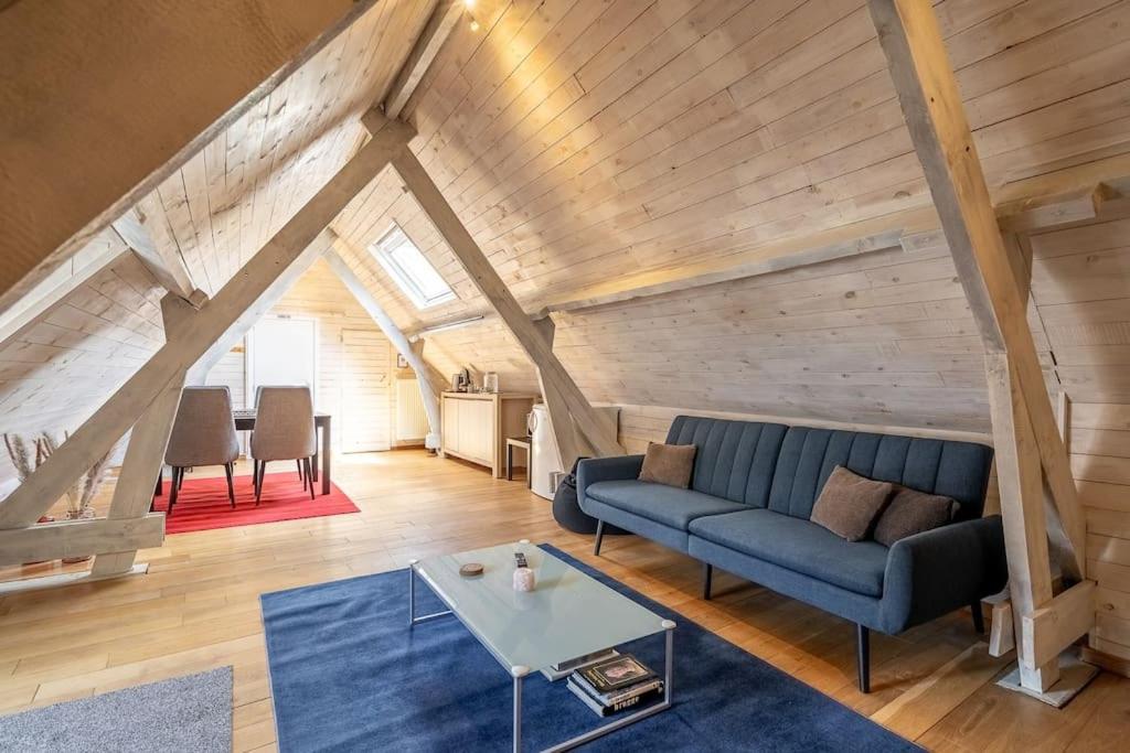 a living room with a blue couch and a table at The Bruges Belfry View in Bruges