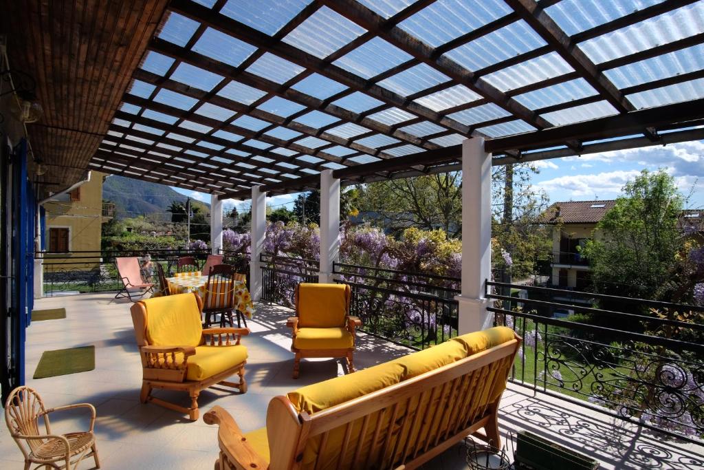 a conservatory with a couch and chairs on a balcony at Dell' Oca in Cissano
