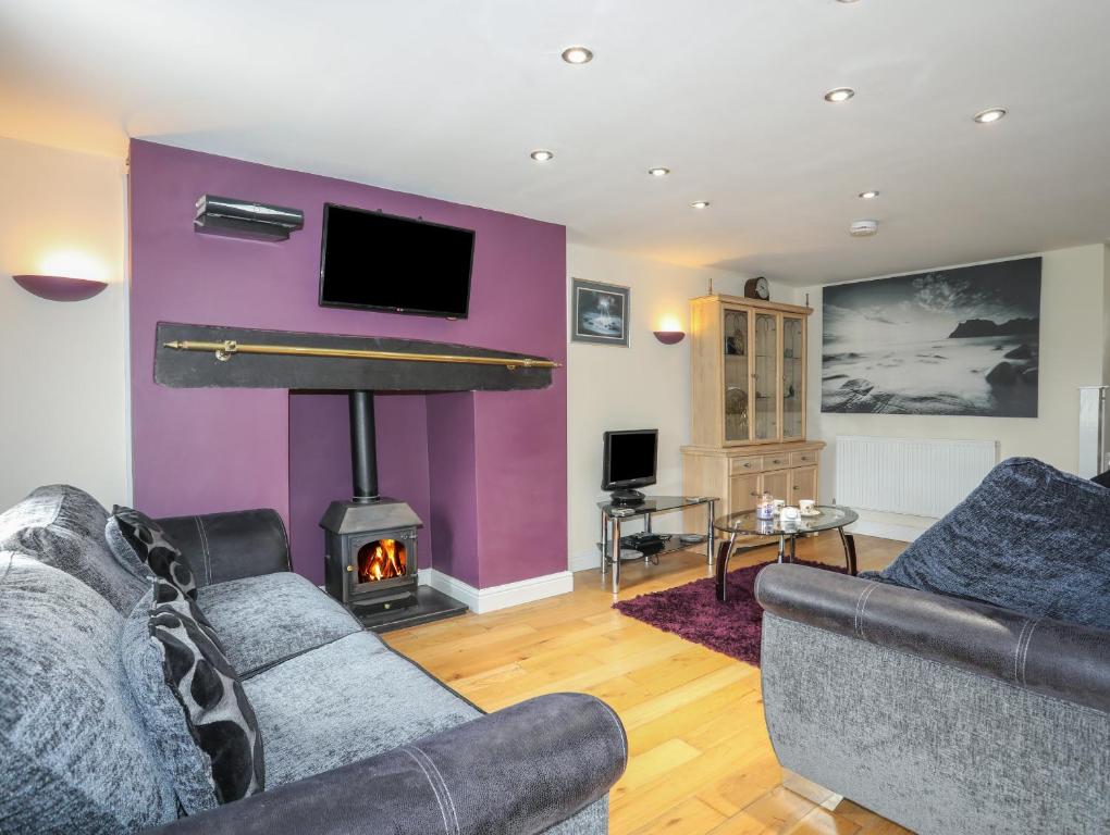 a living room with a couch and a fireplace at 42 Hyfrydle Road in Caernarfon