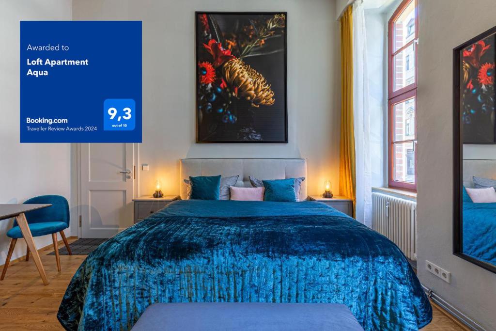 une chambre avec un lit avec une couverture bleue dans l'établissement Loft Apartments Leipzig Loft Aqua, à Leipzig