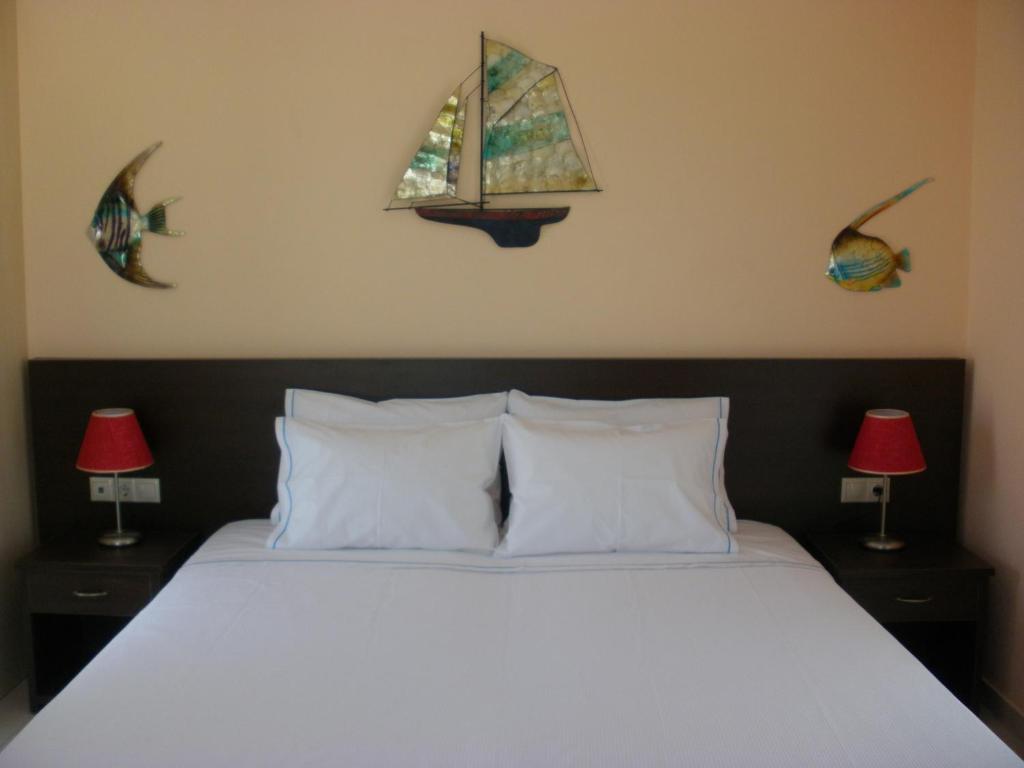 a bedroom with a bed with two lamps and a window at Blue Harmony Apartments in Plaka