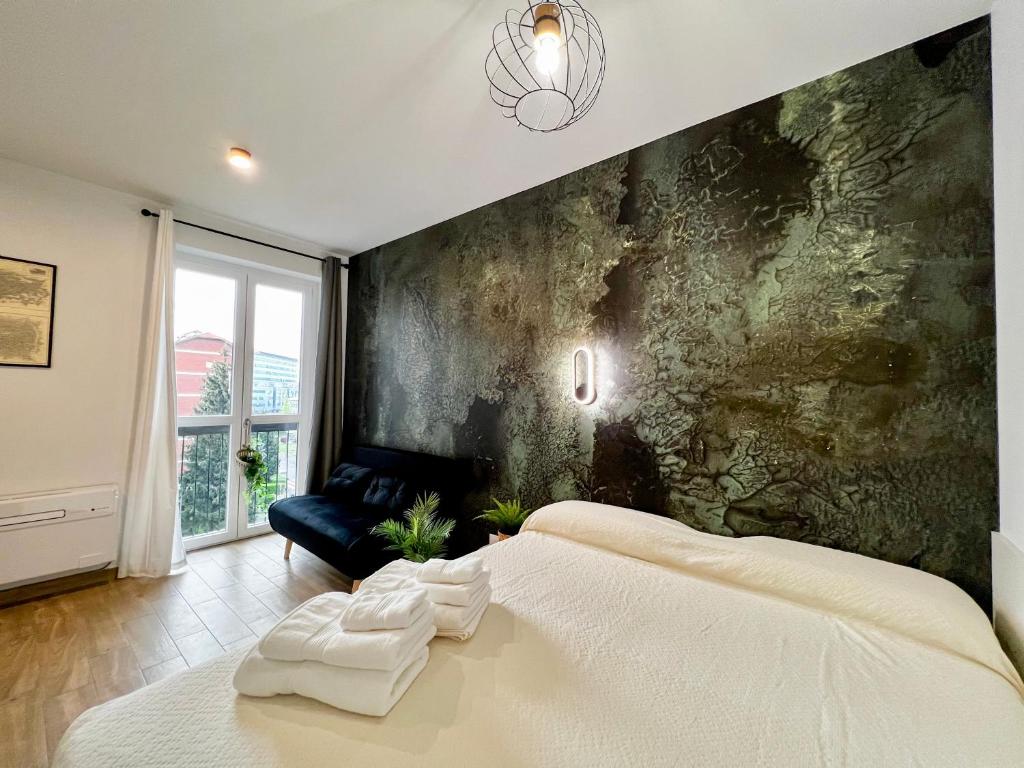 Hotel Repetti Suites - Two Adjacent & Independent Apartments 10 minutes to Milan City Centre & Linate Airport, a bedroom with a large white bed and a wall at Repetti Suites - Two Adjacent & Independent Apartments 10 minutes to Milan City Centre & Linate Airport in Milan