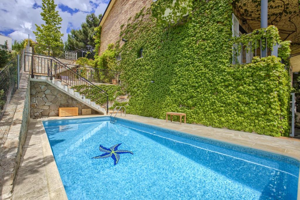 ein Swimmingpool mit einem Seestern vor einem Gebäude in der Unterkunft Casa Serrania in Collado Mediano
