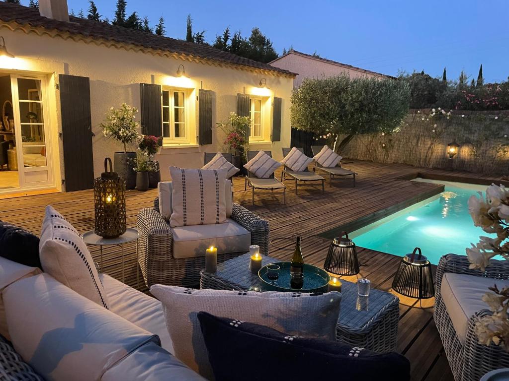 - une terrasse avec des canapés et des chaises à côté de la piscine dans l'établissement Villa Jasmin - Charming & Cosy (Sleeps 6), à Saint-Rémy-de-Provence