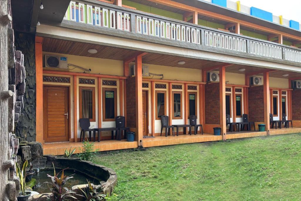 a house with chairs and a balcony on it at Family 24 Hotel near Pantai Cipatujah in Cipatujah