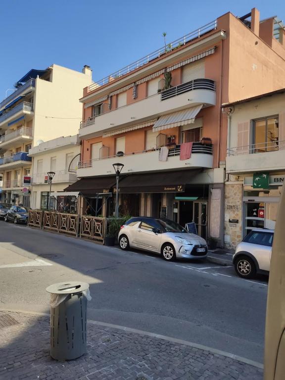 une rue avec des voitures garées devant les bâtiments dans l'établissement Résidence Golfe Riviéra, au Golfe-Juan