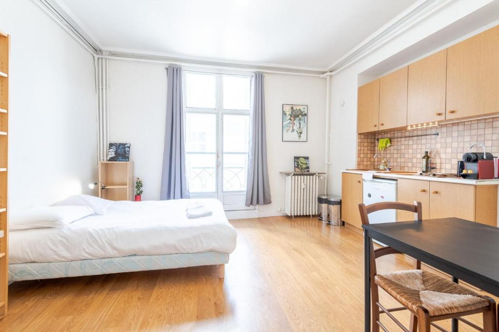 une chambre avec un lit et une table et une cuisine dans l'établissement Le Petit Emile Zola, à Tours
