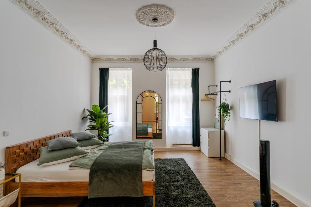 een witte slaapkamer met een bed en een televisie bij bevoflats - Live like a local - Apartment in Kreuzberg, Graefekiez in Berlijn