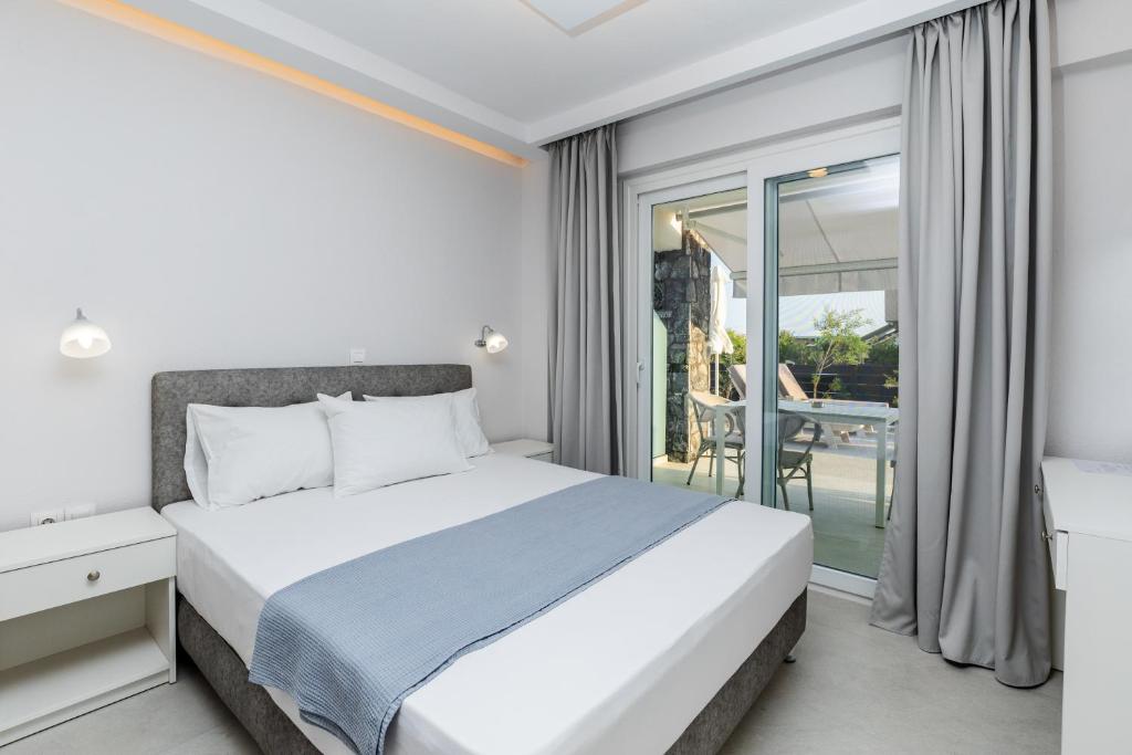 ein Schlafzimmer mit einem Bett und ein Balkon mit einem Tisch in der Unterkunft INTERNI LUXURY LIVING b in Nikiti