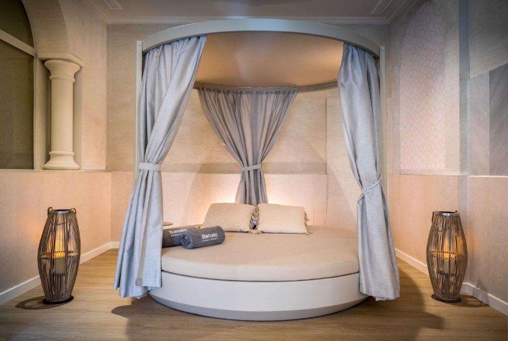 a bed with a canopy in a room with two candles at Barceló Isla Canela in Isla Canela