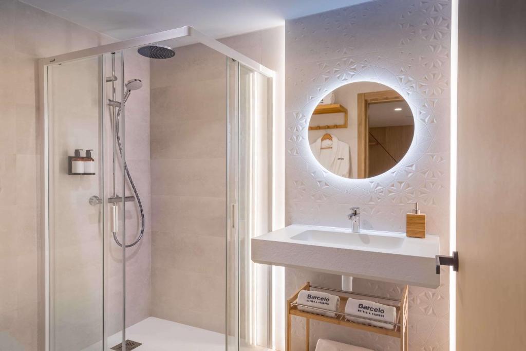 a bathroom with a sink and a shower with a mirror at Barceló Isla Canela in Isla Canela