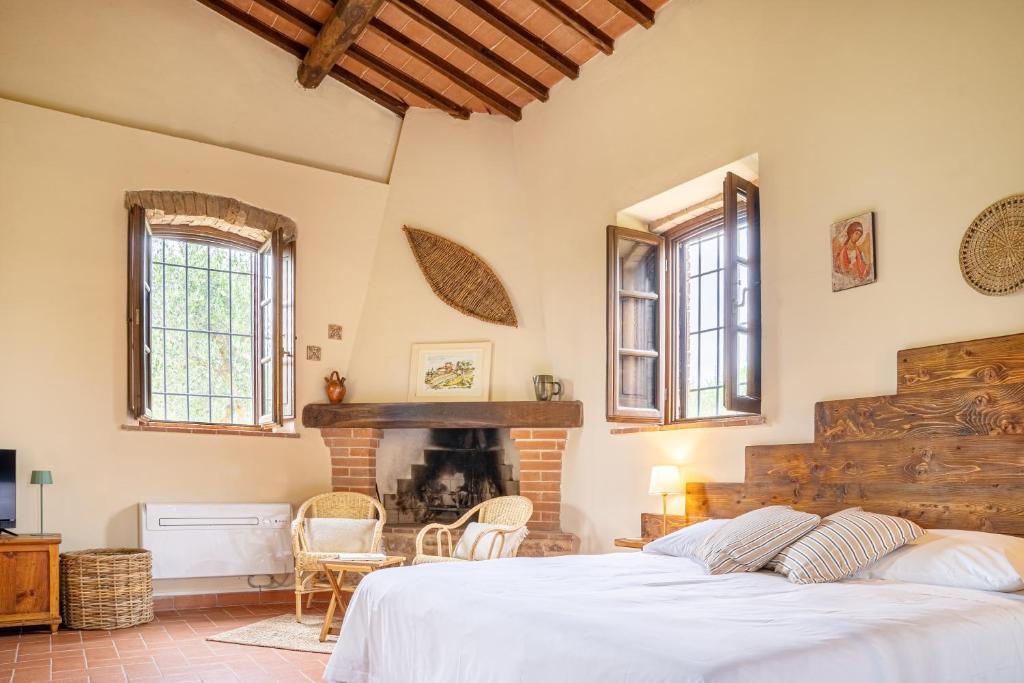 a bedroom with a large bed and a fireplace at La Capanna di Montauto in San Gimignano