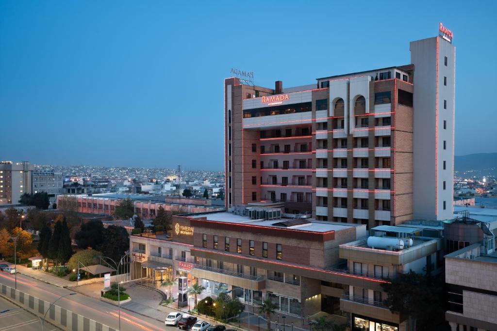 Un edificio alto con un cartel al costado. en Ramada by Wyndham - Sulaymaniyah Salim Street, en As Sulaymānīyah