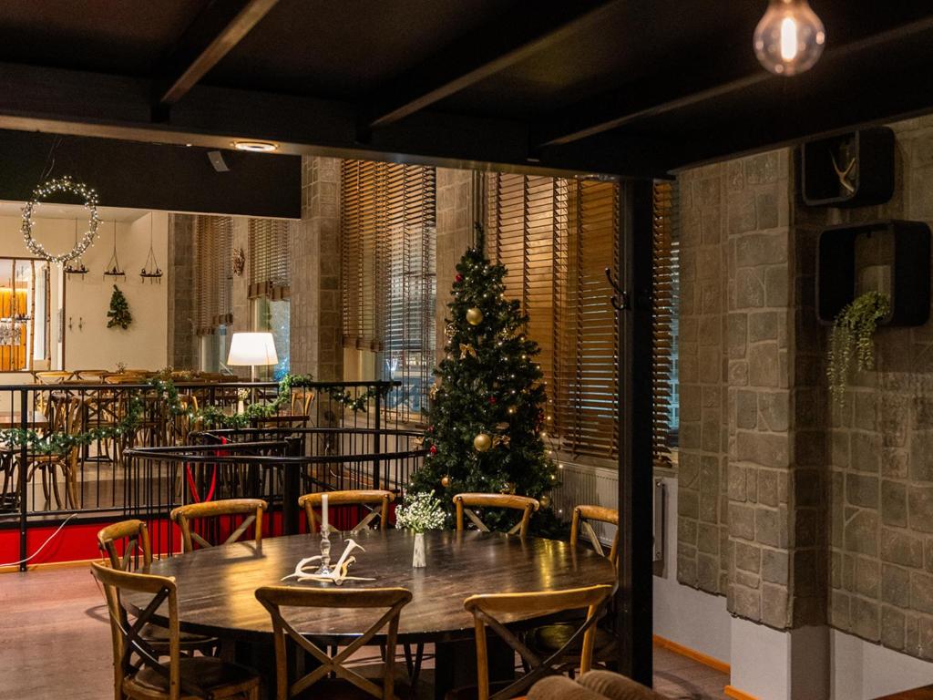 a dining room with a christmas tree and a table at Santa's Hotel Santa Claus in Rovaniemi