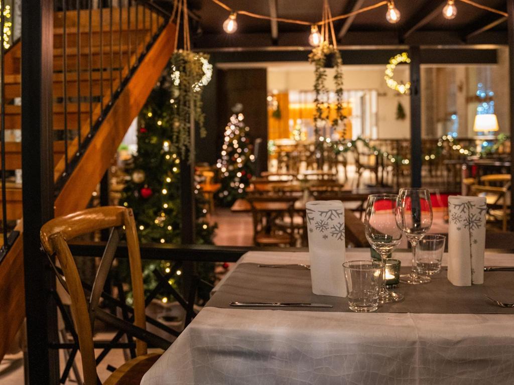 a table with wine glasses and a christmas tree in a restaurant at Santa's Hotel Santa Claus in Rovaniemi