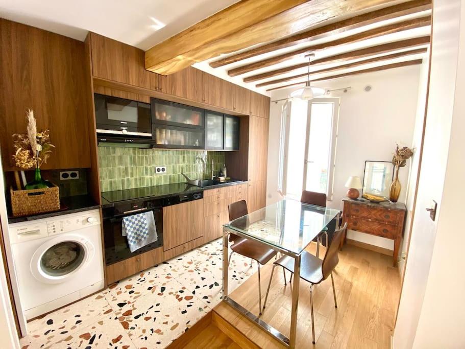 a kitchen with a glass table and a washing machine at Mosaic Villagee -15 mn transport to Champs Élysées in Nanterre