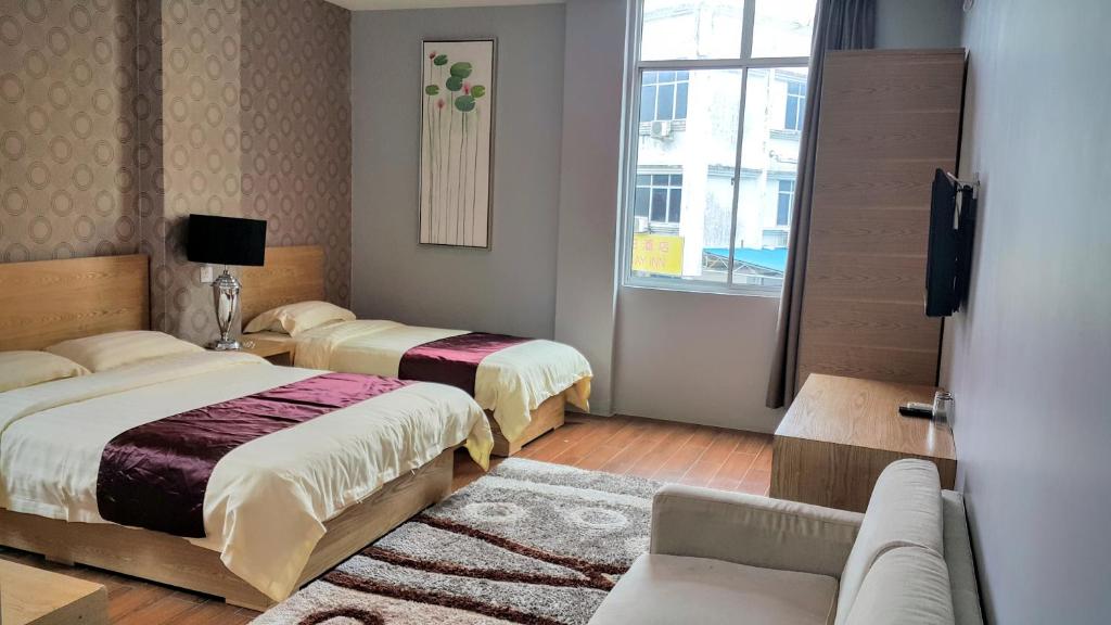 a hotel room with two beds and a couch at Residence 21 Boutique Inn in Miri