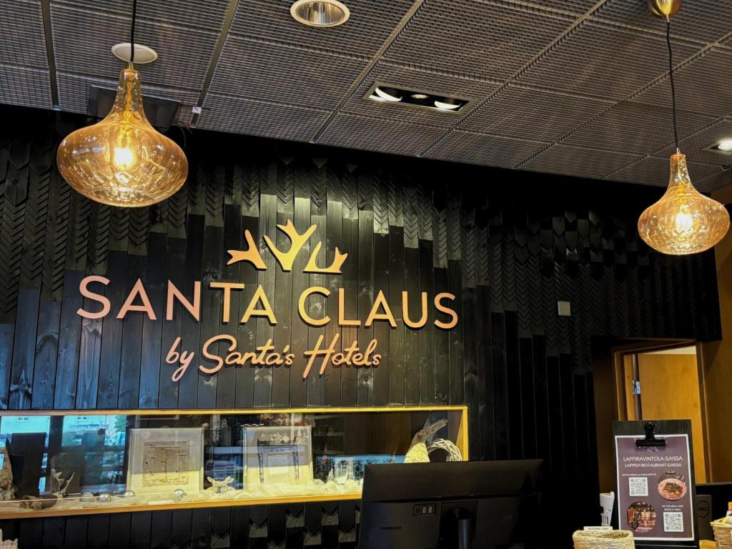 a santa claus hotel sign on the wall of a store at Santa's Hotel Santa Claus in Rovaniemi