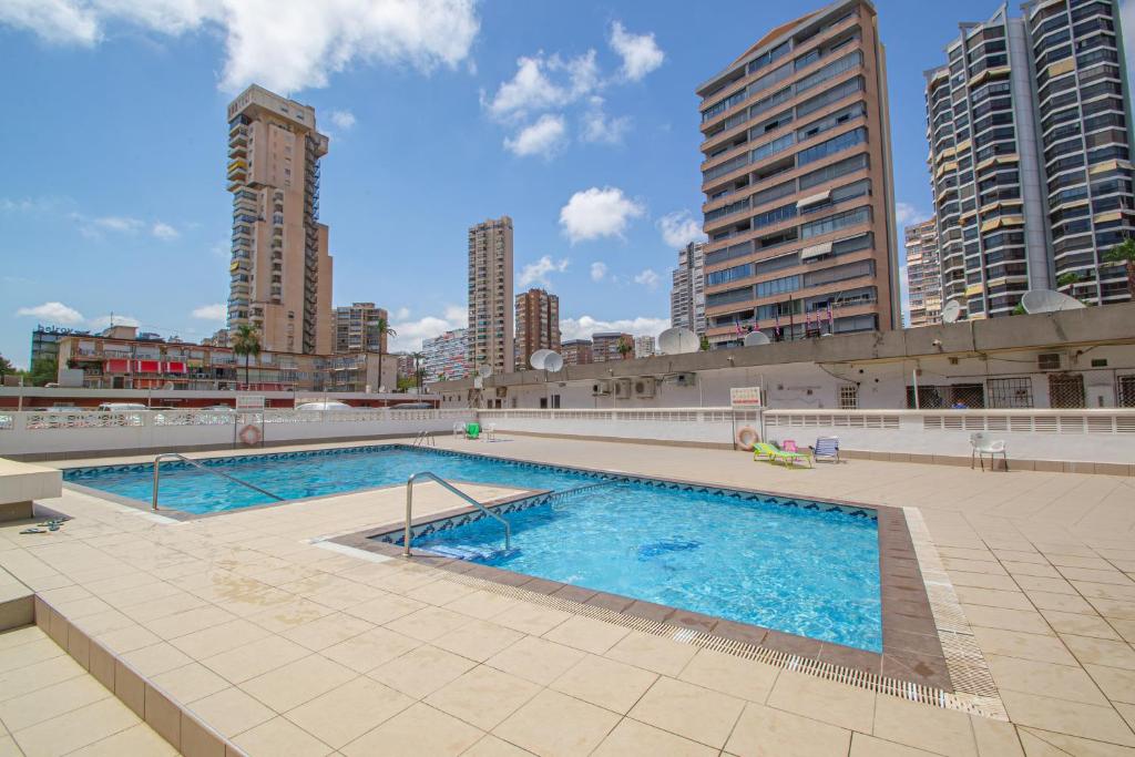 a large swimming pool in a city with tall buildings at Serisol Holidays in Benidorm