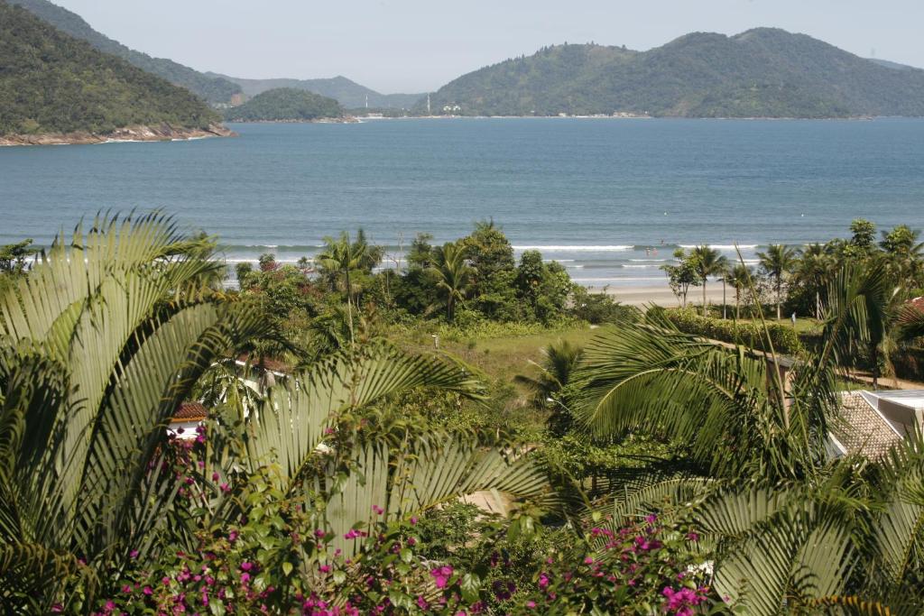 a view of a beach with palm trees and the ocean at Casa Ubatuba vista para o mar in Ubatuba