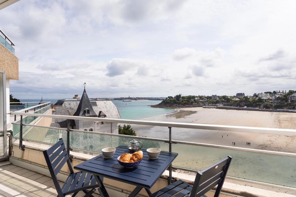 - une table sur un balcon avec vue sur la plage dans l'établissement L'Escale Panoramique - Appt vue mer à Dinard, à Dinard