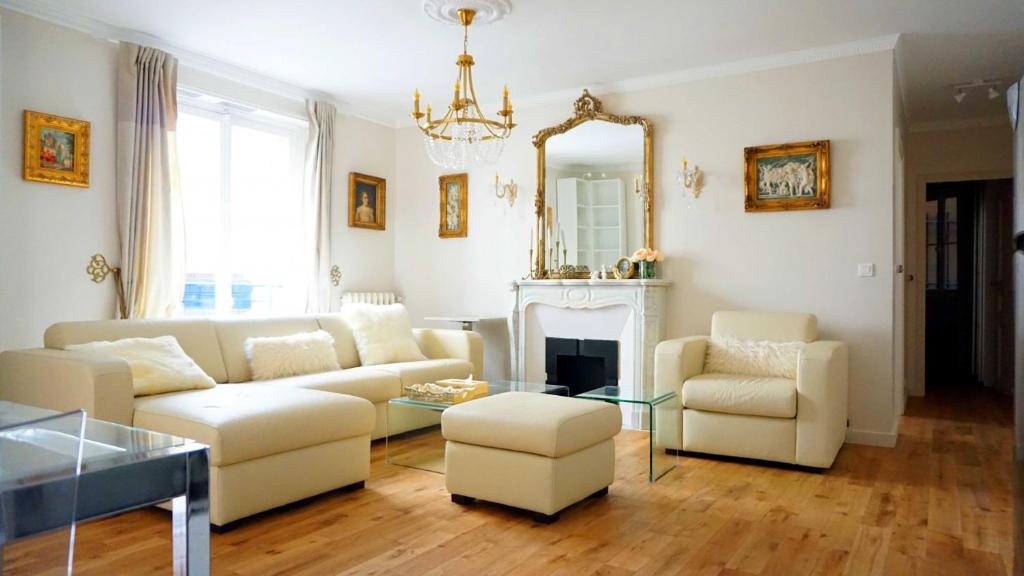 - un salon avec un canapé, des chaises et un miroir dans l'établissement Rue Lauriston - Paris 16, à Paris