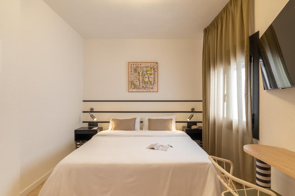 a hotel room with a bed and a table at Hotel Robson - Smart Hotel in Lloret de Mar