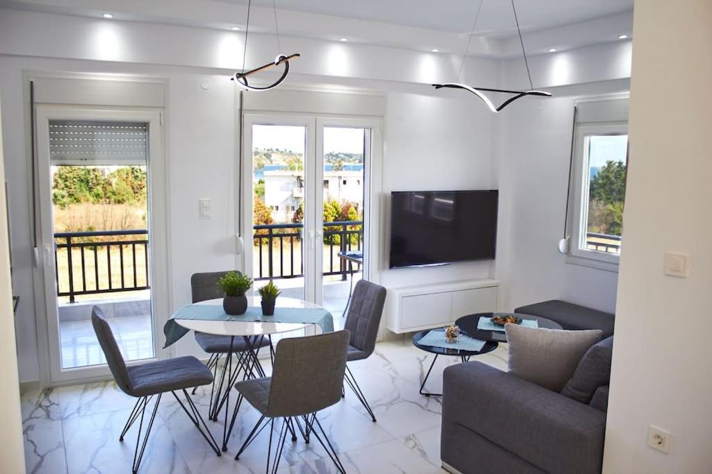 a living room with a couch and a table at Daria’s Luxury Apartment-the hidden gem in Epanomi
