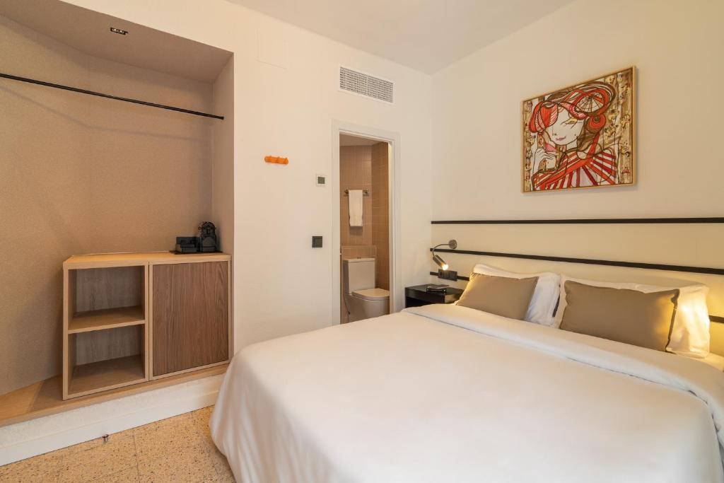 a bedroom with a large white bed and a cabinet at Hotel Robson - Smart Hotel in Lloret de Mar