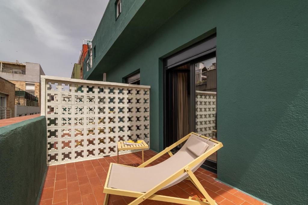 a chair sitting on a patio next to a green wall at Hotel Robson - Smart Hotel in Lloret de Mar